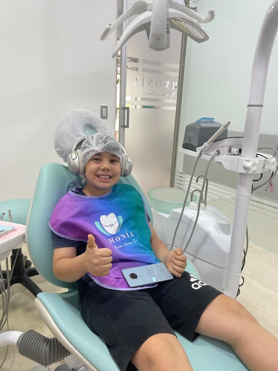Paciente con audífonos de musicoterapia en un sillón dental de Armonía